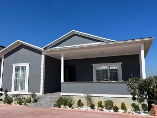 Gri cepheli tek katlı teşhir evi, beyaz söveli geniş veranda ve beyaz çerçeveli pencereler